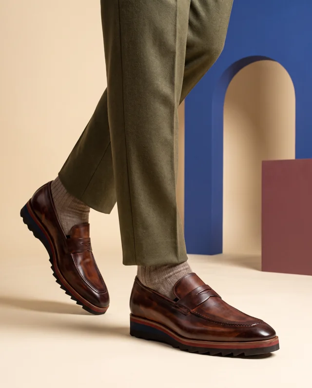 Brown penny loafers with red and navy sole accents
