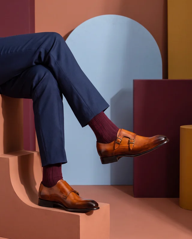 Tan double monk strap shoes styled with navy trousers